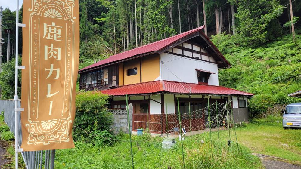 鹿肉カレーののぼりが立つ、古民家の外観